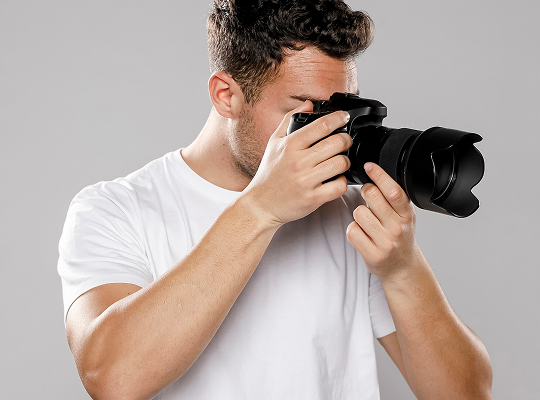fotógrafo vestido de blanco, con una cámara en la mano
